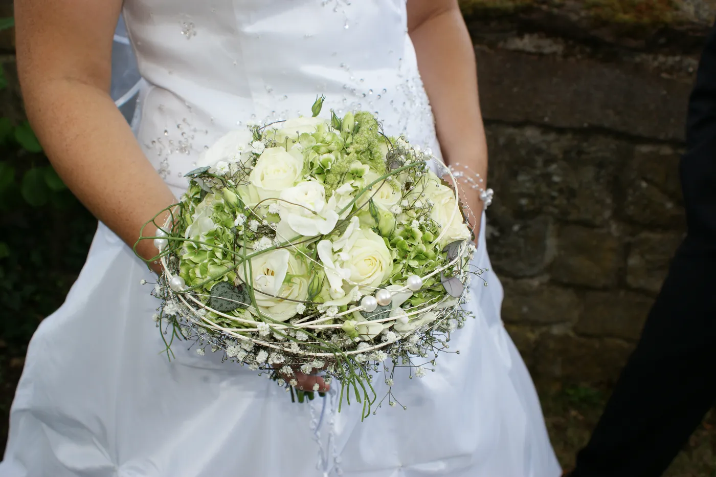 Braut hält einen Brautstrauß aus weißen Rosen