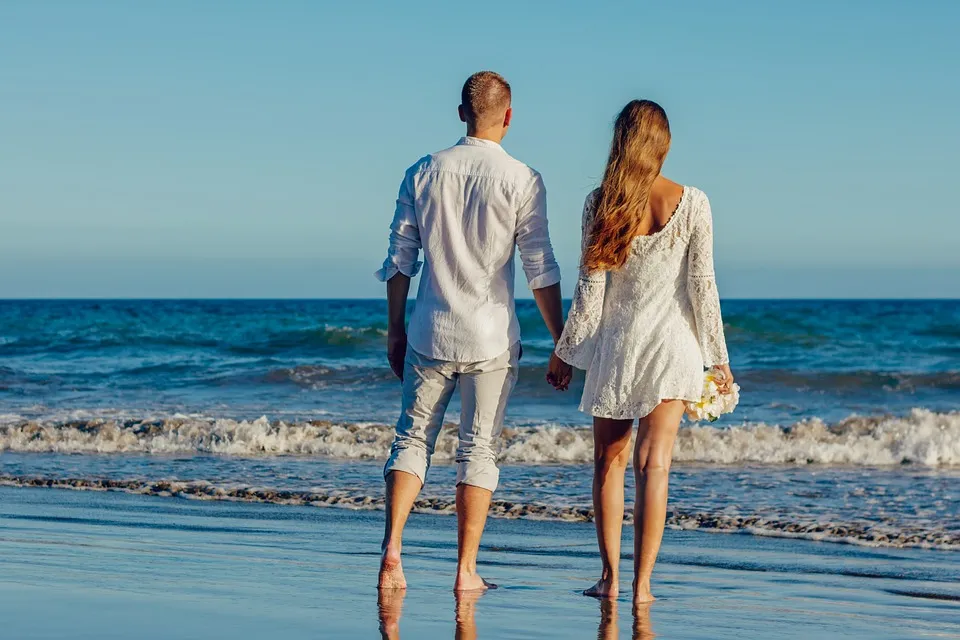 Brautpaar geht Hand in Hand am Meer